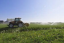 Tractor water aan het geven op het land