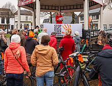 Deelnemers fietstocht op het marktplein luisterend naar dorpsdichter