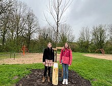 Livine en Lisa bij hun boom en bordje
